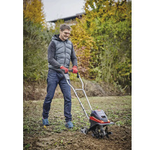 Man werkt met een tuinfrees voor grondbewerking in de tuin.