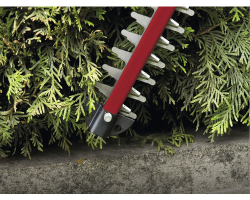 Close-up van een heggenschaar die een haag snoeit