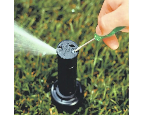 Gazonsproeier wordt afgesteld met een schroevendraaier