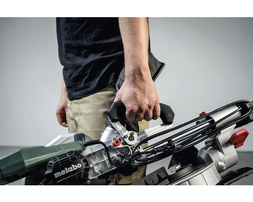 Een persoon houdt een Metabo verstekzaag in zijn handen.