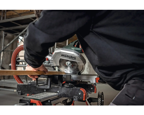 Een Metabo afkort- en verstekzaag KGS 254 M zaagt een houten plank.