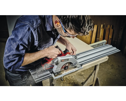 Een man zaagt een houten plank met een invalzaag en geleiderail van Einhell.