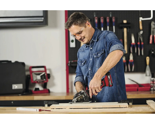 Man werkt met een draadloze handcirkelzaag aan een stuk hout