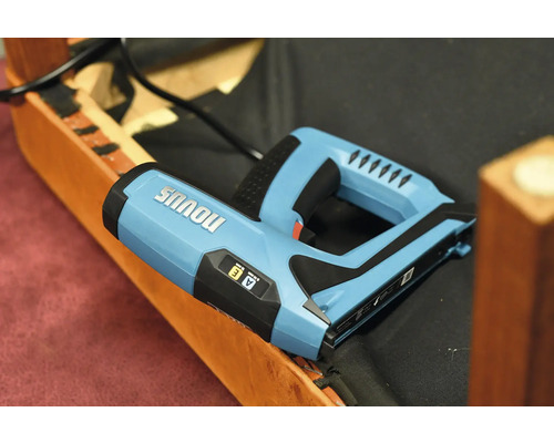 Elektrische tacker van het merk Novus op een meubelstuk