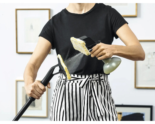 Vrouw gebruikt een stoomreiniger met verschillende hulpstukken voor reiniging