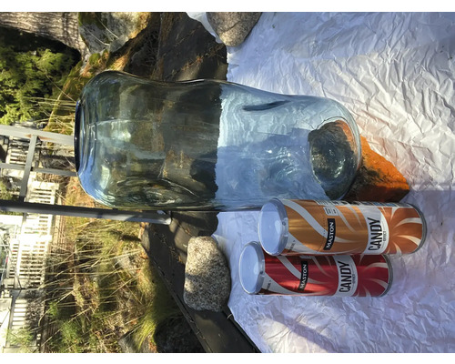 Grote glazen vaas met twee spuitbussen verf