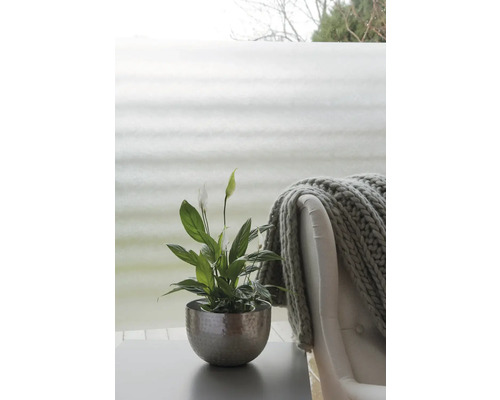 Vredeslelie in een pot op een tafel naast een fauteuil met een deken