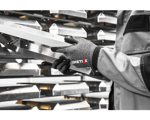 Persoon houdt een zilverkleurige metalen rail vast met werkhandschoenen