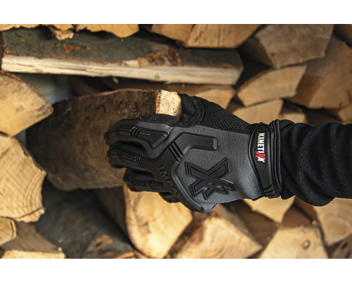 Hand met werkhandschoen houdt houten blok vast voor een stapel hout