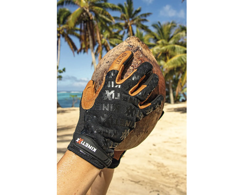 Hand met KINETIXX werkhandschoenen houdt kokosnoot vast op strand