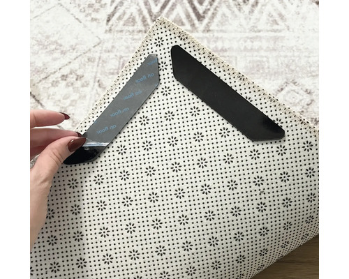 Twee antislip-hoekstukken voor tapijten op een tapijt om te bevestigen en te fixeren.