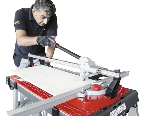 Man snijdt tegel met tegelsnijder op een tafel