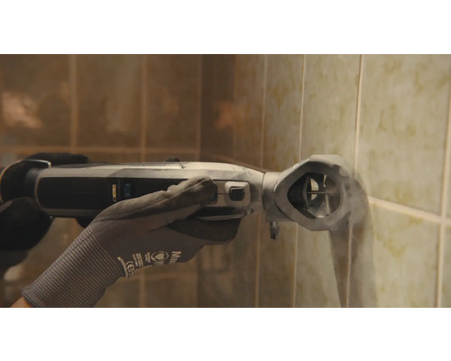 Een persoon gebruikt een oscillerend elektrisch gereedschap op een betegelde muur.