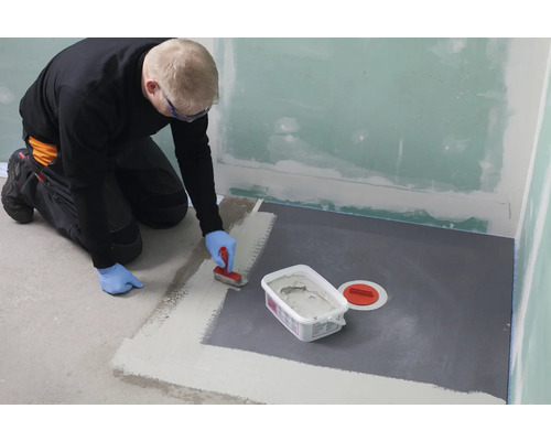 Man dicht badkamervloer af met afdichtingsmiddel