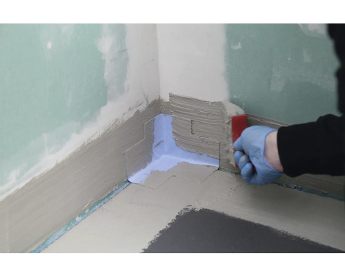 Afdichting van een hoek met afdichtingsslib in de badkamer