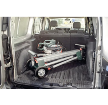 Metabo logo. In de laadruimte van een bestelwagen staat een afkort- en verstekzaag met onderstel.