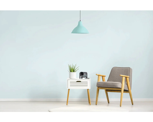 Woonkamer met fauteuil, bijzettafel, kamerplant en hanglamp