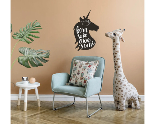 Decoratieve kinderkamer met fauteuil, giraffe knuffeldier en eenhoorn muursticker