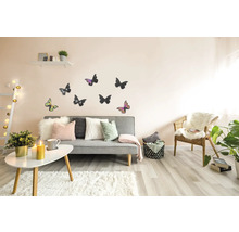 Woonkamer met grijze bank, kussens, vloerkleed, tafel, stoel, wanddecoratie en kamerplanten voor een gezellige sfeer.