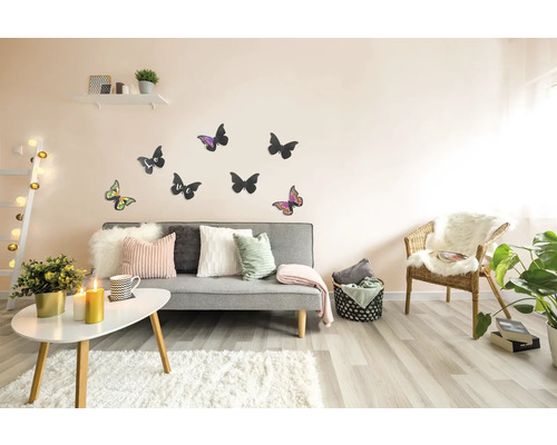 Woonkamer met grijze bank, kussens, vloerkleed, tafel, stoel, wanddecoratie en kamerplanten voor een gezellige sfeer.