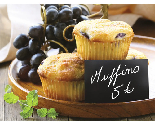 Twee muffins met prijskaartje en druiven op een houten dienblad