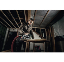 Vakman met veiligheidsbril zaagt hout met een cirkelzaag van Metabo in een casco.
