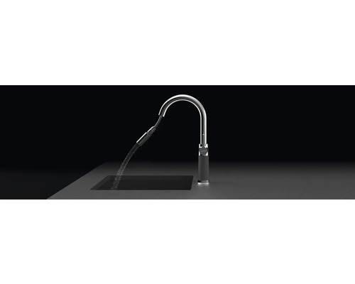 Keukenkraan met waterstraal in een gootsteen