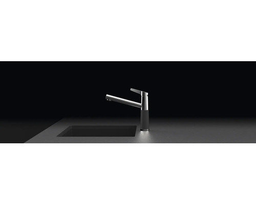 Metalen keukenkraan met modern design naast een spoelbak.
