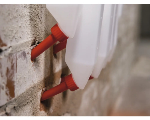 Detailopname van vloeistofreservoirs met wanddoorvoer in metselwerk.