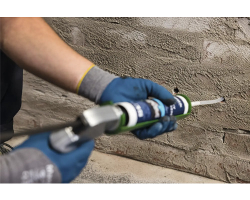 Ambachtsman vult een gat in een muur met afdichtmiddel