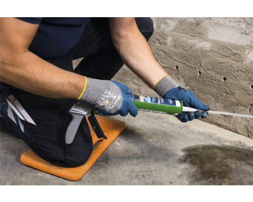 Ambachtsman gebruikt een patroonpistool op een bouwplaats.