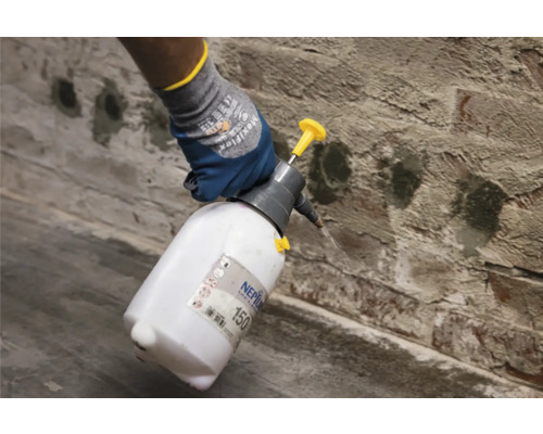 Gebruik van een spuitfles op een bakstenen muur.