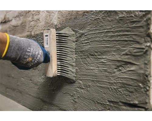 Lijm aanbrengen met een lijmkam op een muur