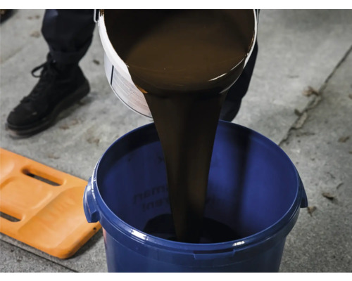 Vloeistof wordt in een blauwe emmer gegoten
