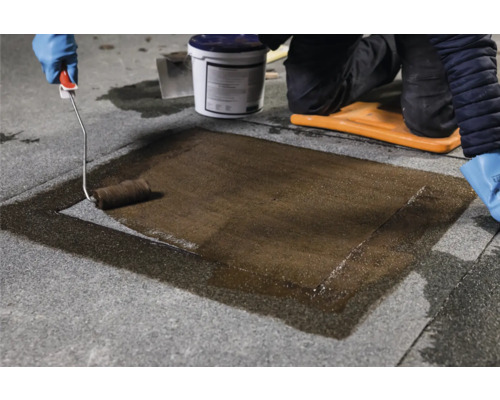 Aanbrengen van een coating op stenen tegels met een verfroller, emmer en kniebeschermers