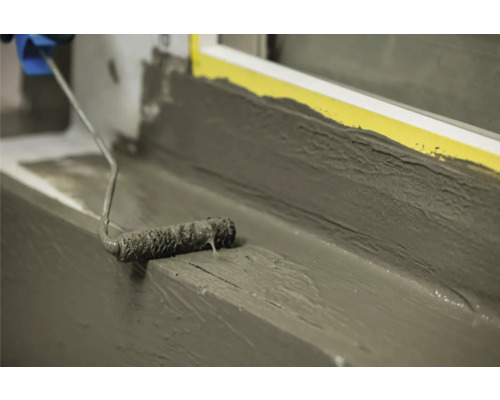 Aanbrengen van flexibele afdichtingsmortel met een verfroller op een vensterbank