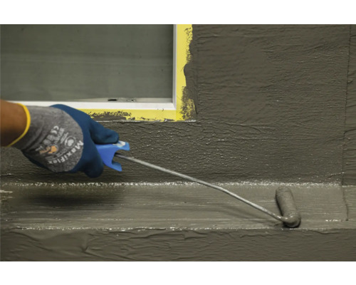 Aanbrengen van een afdichting met een verfroller op een oppervlak nabij een raam