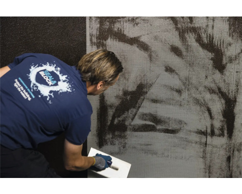 Aanbrengen van waterdichte coating op een muur met een spaan