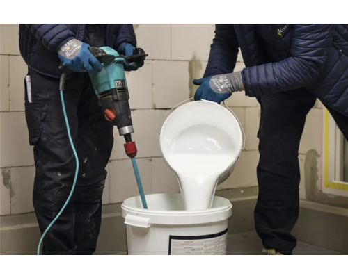 Ambachtslieden mengen verf met een verfmixer in een emmer.