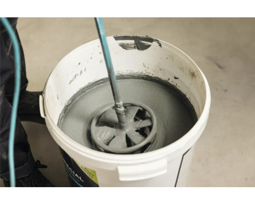 Mortel wordt gemengd in een emmer met een mixer.