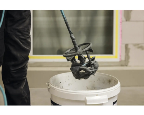 Mortel wordt gemengd met een mixer in een emmer