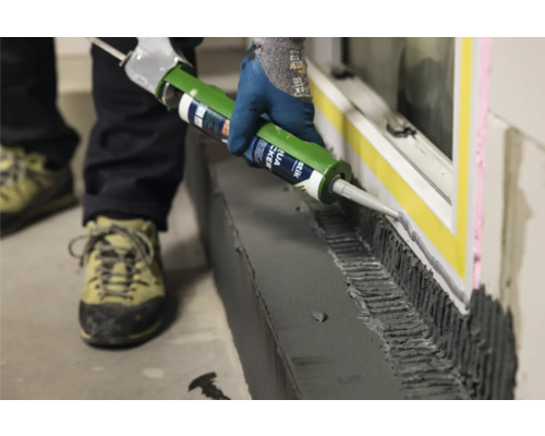 Iemand brengt lijm aan op een raam met een kitspuit