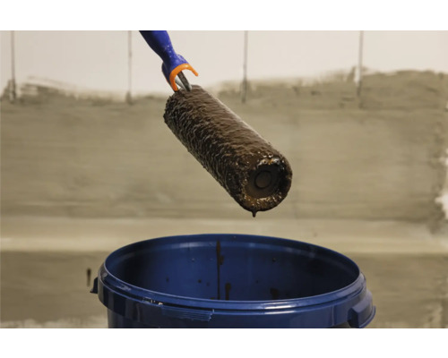 Verfroller met verf boven een verfemmer