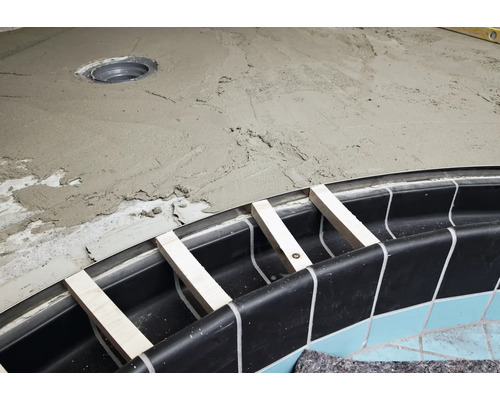 Installatie van een douchebak met dekvloer, afvoer en houten steunen.