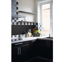 Keukenhoek met gootsteen, werkblad, keukengerei en hangende planken.