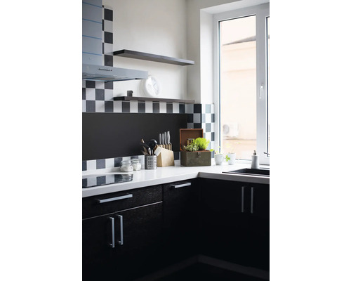 Keukenhoek met gootsteen, werkblad, keukengerei en hangende planken.