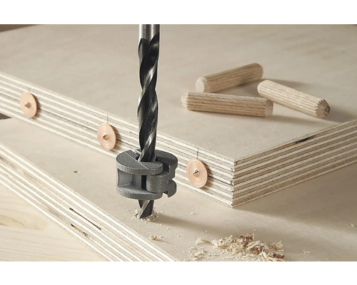 Foto van een plugboor in gebruik met pluggen en houten platen