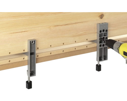 Houten plank wordt bewerkt met een boormachine en een boormal