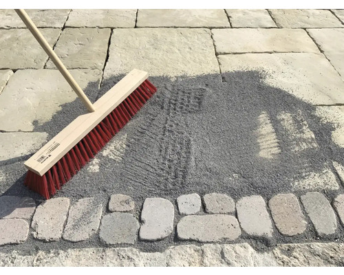 Bezem om straatzand in te vegen op een bestrate oppervlakte