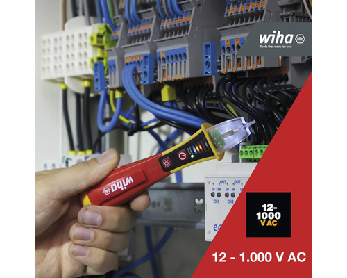 Wiha logo. Een hand houdt een spanningszoeker vast voor een verdeelkast. De spanningszoeker is geschikt voor 12 tot 1.000 volt wisselspanning.